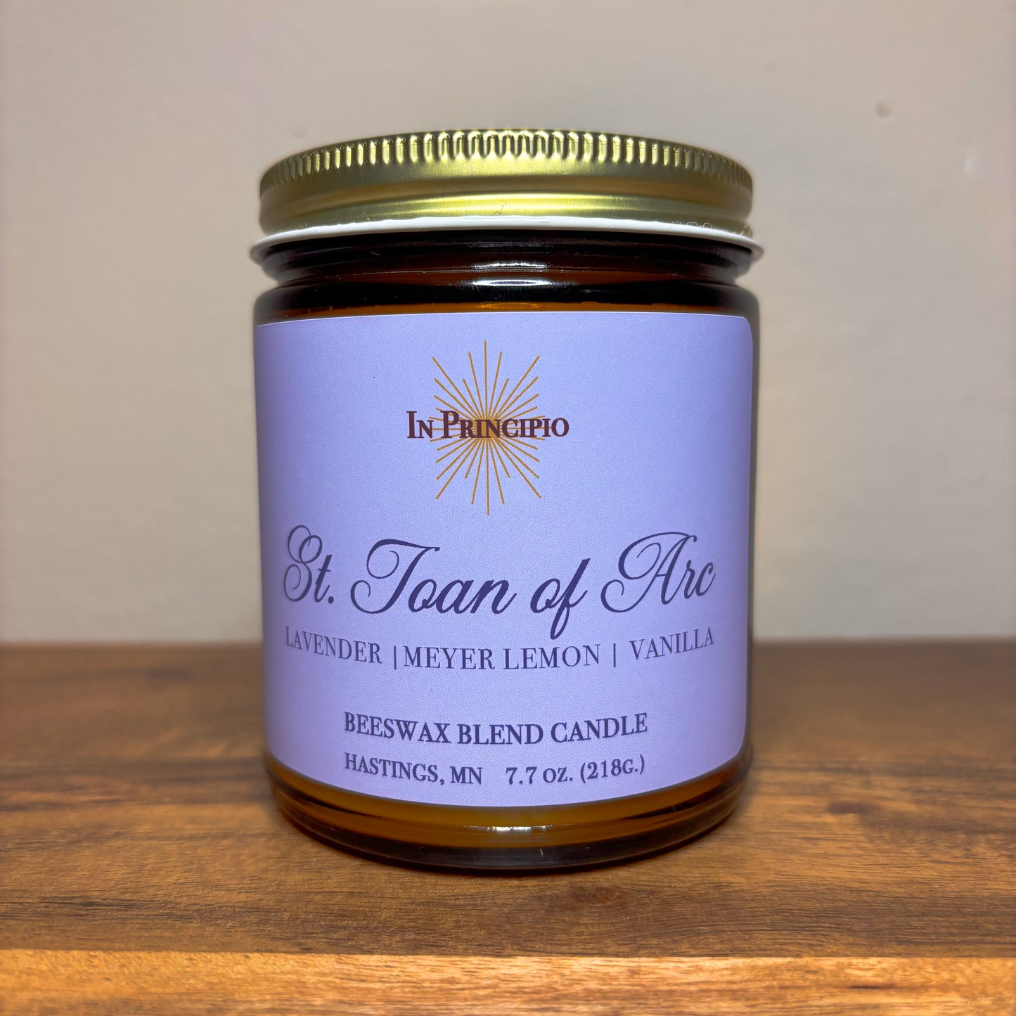 Candle jar with purple label on a wooden surface