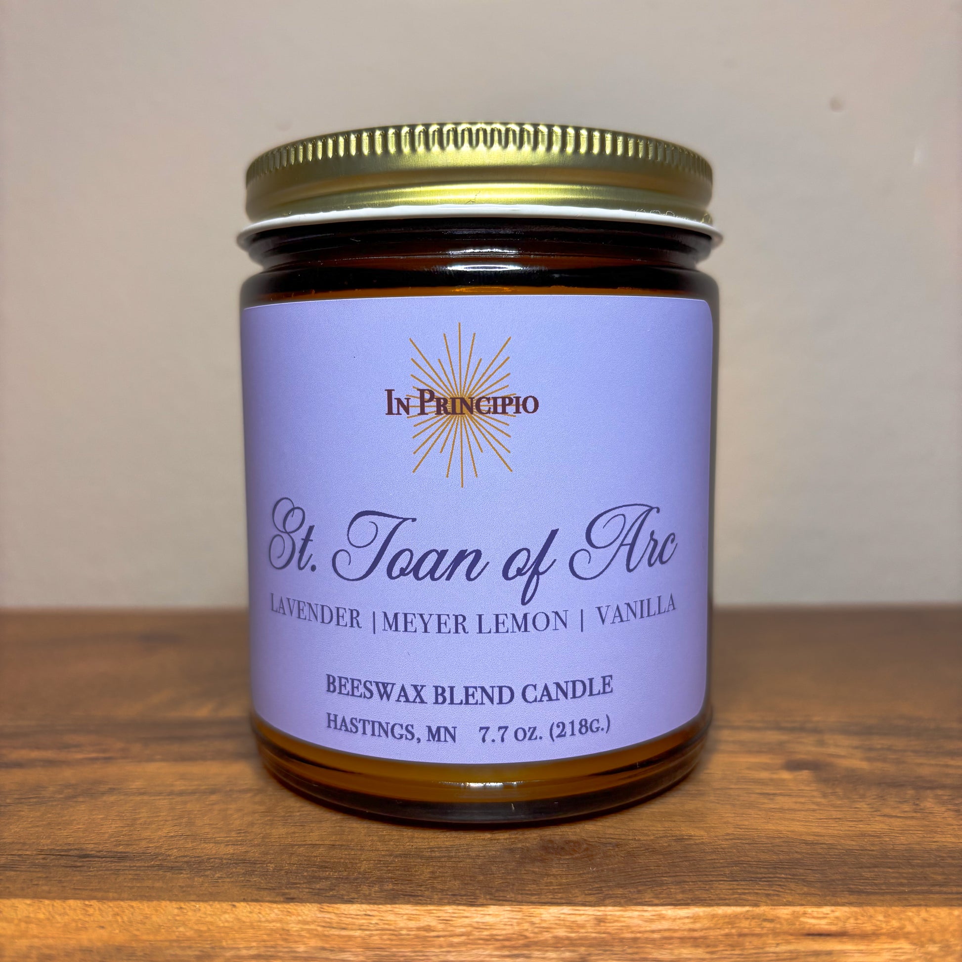 Candle jar with purple label on a wooden surface
