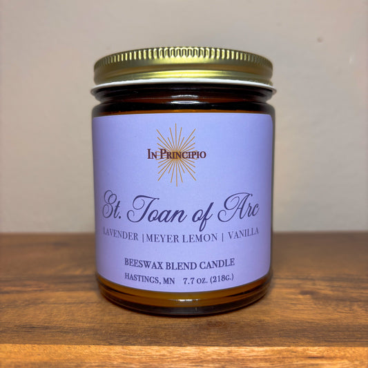 Candle jar with purple label on a wooden surface